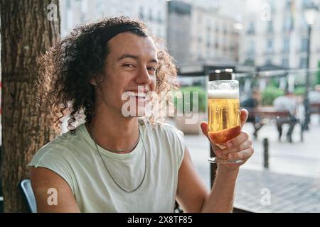 Porträt eines lächelnden Mannes, der ein Bier in der Hand hält. Stockfoto