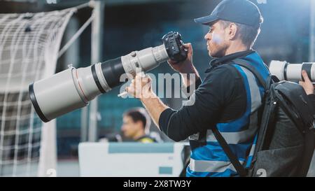 Professioneller Pressesprecher, Sportfotografen mit Kamera mit Zoomobjektiv Shooting Football Championship Match in einem Stadion. Internationaler Pokal, World Tournament Event. Fotografie, Journalismus, Medien Stockfoto