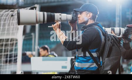 Professioneller Pressesprecher, Sportfotografen mit Kamera mit Zoomobjektiv Shooting Football Championship Match im Stadion. Internationaler Pokal, World Tournament Event. Fotografie, Journalismus, Medien Stockfoto