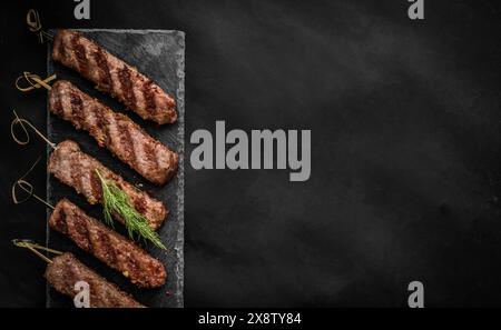 Gegrillter Kebab mit Gewürzen auf dunklem Hintergrund Stockfoto