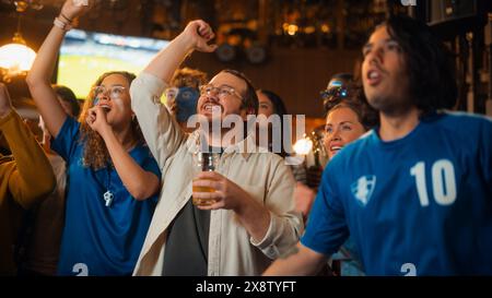 Die Mitglieder des Fußballclubs jubeln ihr Team an und spielen in einem Finale des Internationalen Pokals. Unterstützende Fans, die in einer Bar stehen, jubeln, die Hände heben und schreien. Freunde feiern den Sieg nach dem Tor. Stockfoto