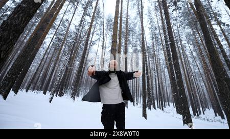 Porträt eines hübschen jungen bärtigen Mannes in warmer Kleidung, der draußen im Park am Wintertag steht. Medien. Hipster-blondes Modell im Wald. Stockfoto