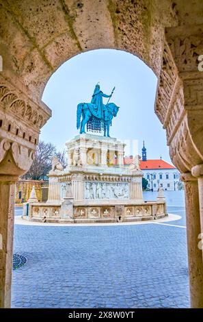 Der Blick auf die St. Stephan Statue auf dem Heiligen Dreifaltigkeitsplatz durch den Bogen der Steingalerie der Fischerbastei, Budapset, Ungarn Stockfoto