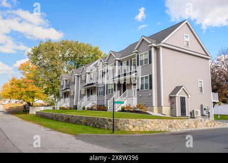 Neu gebaute Reihenhäuser in einer Wohnsiedlung unter blauem Himmel im Herbst Stockfoto