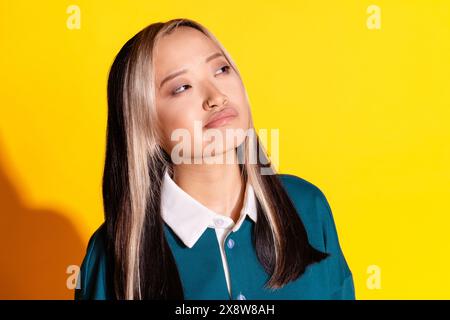 Foto des verwirrten Mädchens mit gefärbtem Haar gekleidetes türkisfarbenes Hemd Blick auf Angebot leeren Raum isoliert auf lebhaftem gelbem Hintergrund Stockfoto