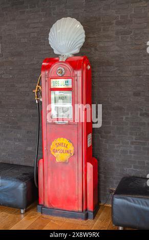 Sie stellte eine altmodische amerikanische Benzinpumpe der Marke Shell aus Stockfoto