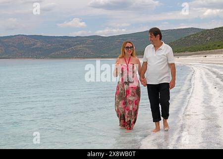 Junger Mann und Frau, die am Strand des Salda-Sees spazieren. Stockfoto