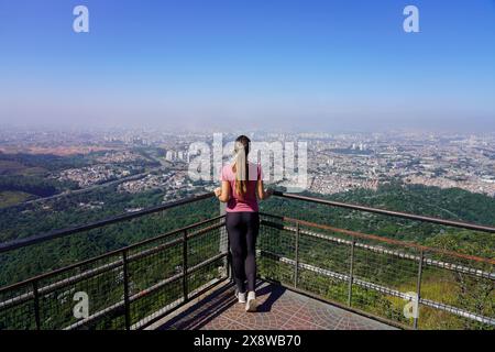 Junge Frau genießt das Stadtbild von Sao Paulo vom Jaragua Peak, dem höchsten Berg der brasilianischen Stadt Sao Paulo Stockfoto