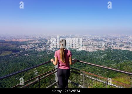 Junge Frau genießt das Stadtbild von Sao Paulo vom Aussichtspunkt Jaragua Peak, Sao Paulo, Brasilien Stockfoto