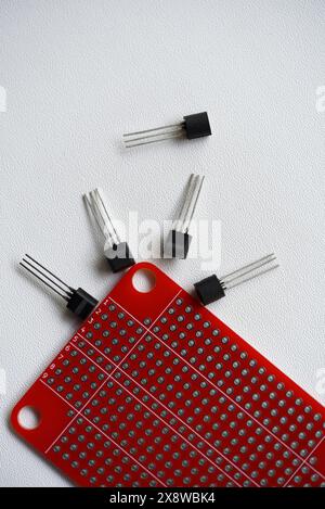Rote Leiterplatte und Chips und Funkkomponenten. Kondensatoren und Transistoren. Stockfoto
