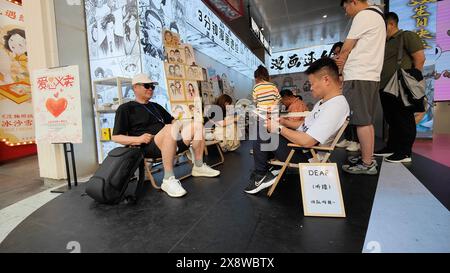 Shanghai, China. Mai 2024. Ein Hörgeschädigter Künstler malt am 24. Mai 2024 ein Cartoon-Porträt südkoreanischer Touristen in der Nanjing Road in Shanghai, China. (Foto: Costfoto/NurPhoto) Credit: NurPhoto SRL/Alamy Live News Stockfoto