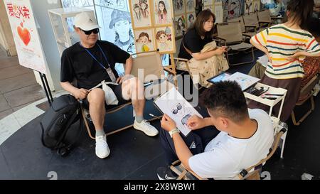 Shanghai, China. Mai 2024. Ein Hörgeschädigter Künstler malt am 24. Mai 2024 ein Cartoon-Porträt südkoreanischer Touristen in der Nanjing Road in Shanghai, China. (Foto: Costfoto/NurPhoto) Credit: NurPhoto SRL/Alamy Live News Stockfoto