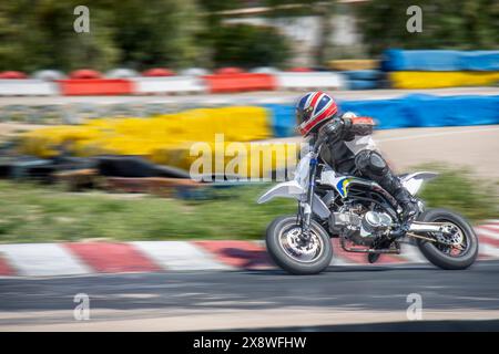 Motorradrennfahrer im Vollgang beschleunigen auf einer Rennstrecke mit Bewegungsunschärfe. Stockfoto