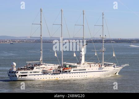 Die Windstar Luxury Kreuzfahrtschoner rutscht ihre Anlegestellen und segelt den Fluss Tejo hinunter, um wieder auf das offene Meer zu fahren, um ihre geplante Kreuzfahrt fortzusetzen. Stockfoto