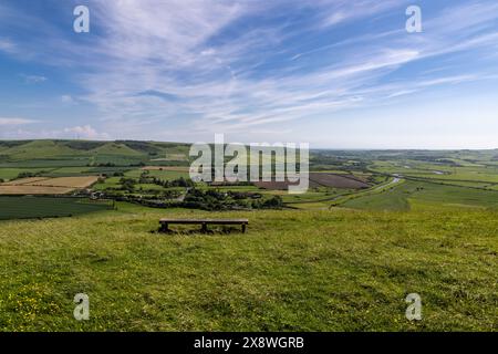 Eine Bank am Mount Caburn mit Blick auf Felder und den Fluss Ouse bei Lewes, an einem sonnigen Frühlingstag Stockfoto