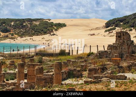 Die markanten römischen Ruinen von Baelo Claudia in der Nähe von Cadiz, Spanien, zeigen die beeindruckende Duna de Bolonia im Hintergrund Stockfoto