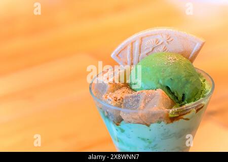 Ein traditionelles japanisches Dessert-Matcha-Eis-Parfait mit Agar-Gelee-Würfeln, bestreut mit geröstetem Sojabohnenmehl, dem sogenannten Kinako-Pulver und einem Higas Stockfoto