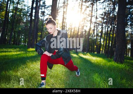 Sportliche Frau im Trainingsanzug, die im Park Outdoor-Übungen macht. Stockfoto