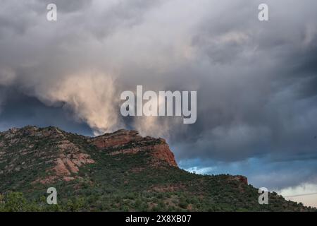 Sturmwolken reflektieren Sonnenlicht über roten Felsformationen in der Nähe von Sedona, Arizona Stockfoto