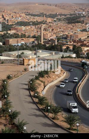 Trans-Sahar Highway N1 mit der Stadt Sidi Abaz und Ksar Bounoura im Hintergrund. Mzab-Tal. Provinz Ghardaia. Algerien Stockfoto