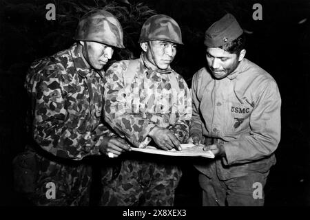 Navajo-Code-Sprecher, Mitglieder der Signalgesellschaft, die mit der 1. Marine-Division im Südwesten des Pazifiks verbunden sind, untersuchen ein Nachtproblem an der Amphibious Scout School, die von der Geheimdienstabteilung während des Zweiten Weltkriegs 1943 durchgeführt wurde. Stockfoto