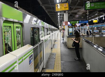 Japanische Passagiere warten auf die JR Yamanote-Linie in Tokio, Japan. Stockfoto