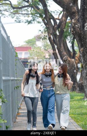 Studenten gehen gemeinsam im Freien, eine Gruppe glücklicher Freunde auf dem Campus. Stockfoto