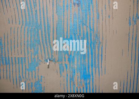 Zuerst Schicht Konstruktionsklebstoff auf isolierte Wand zur Abdeckung von Verstärkungsgitter, Glasfaser über Styropor, Fassade mit Temperaturisolierung. Stockfoto