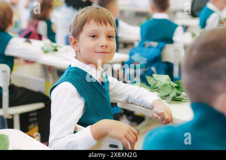 Süßer kleiner Junge Sittimg in der Schule. Erster september. Wissenstag Stockfoto