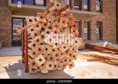 Stapel rostiger Metallrohre in improvisierter Palette, Träger, für den Transport zerlegter Gerüste zur neuen Baustelle. Stockfoto