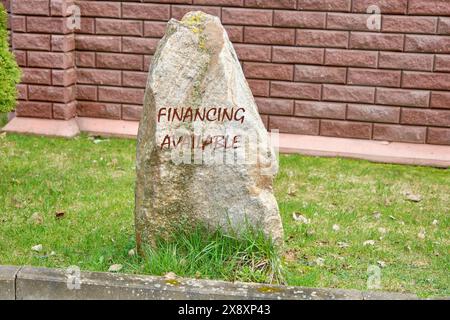 Geschäftskonzept. Die Finanzierung steht auf dem Stein in der Nähe des Zauns auf dem Gras zur Verfügung Stockfoto