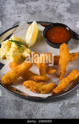 Frittierte Garnelentempura mit Kartoffelsalat auf einem Metallteller Stockfoto