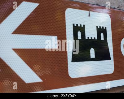 Cremona, Italien - 15. Mai 2024 Nahaufnahme eines strukturierten braunen Schildes mit einem weißen Burgsymbol und Richtungspfeil, das eine historische Stätte oder ein Landma anzeigt Stockfoto