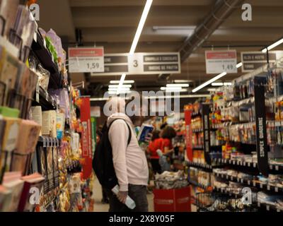 Cremona, Italien - 15. Mai 2024 Kunden prüfen Produkte in Supermarktregalen, üben soziale Distanzierung und tragen Masken für Gesundheitsschutz in Stockfoto