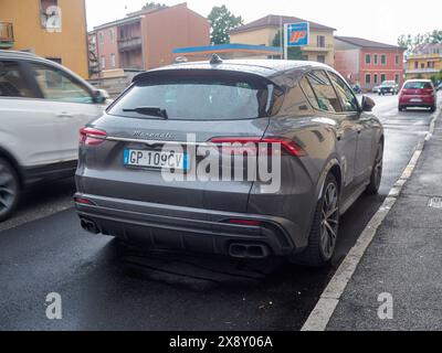 Cremona, Italien - 15. Mai 2024 Großaufnahme eines eleganten, luxuriösen Maserati suv Grecale Trofeo Seitenverkleidung und Rad, glitzernd von Regentropfen unter bewölktem Himmel Stockfoto