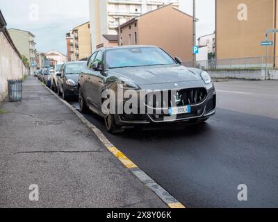 Cremona, Italien - 15. Mai 2024 Großaufnahme eines eleganten, luxuriösen Maserati suv Grecale Trofeo Seitenverkleidung und Rad, glitzernd von Regentropfen unter bewölktem Himmel Stockfoto