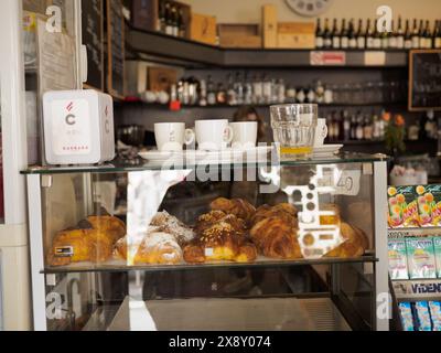 Cremona, Italien - 15. Mai 2024 warme und einladende Café-Inneneinrichtung mit einer Glaspräsentation mit frischem Gebäck, Espresso-Tassen und einer alten Kasse Stockfoto