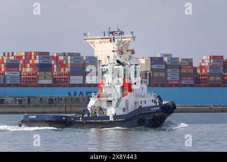 Le Havre, Frankreich - Blick auf den Hafenschlepper VB DEAUVILLE kreuzt vor einem Containerschiff im Hafen von Le Havre. Stockfoto