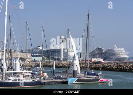 Le Havre, Frankreich - Blick auf den Yachthafen mit Segelbooten vor Anker und zwei Kreuzfahrtschiffen neben dem Hafen von Le Havre. Stockfoto