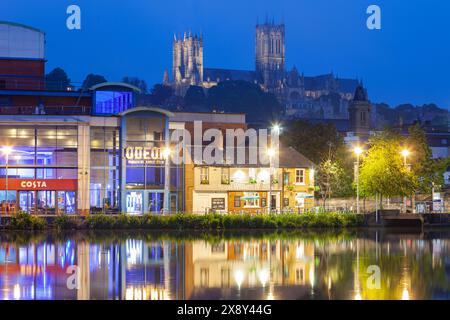 Die Nacht fällt am Brayford Pool in Lincoln, England. Die Lincoln Cathedral dominiert die Skyline. Stockfoto