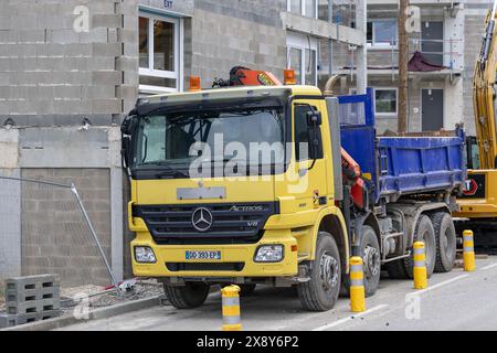 Nancy, Frankreich – Gelb-Blau-Muldenkipper Mercedes-Benz Actros 4151 auf einer Baustelle. Stockfoto