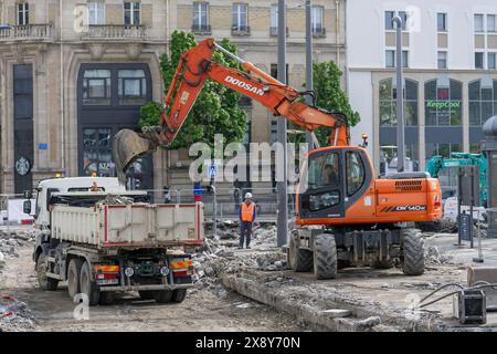 Nancy, Frankreich – orangefarbener Radbagger Doosan DX140W beim Verladen eines Lkws auf der Baustelle. Stockfoto