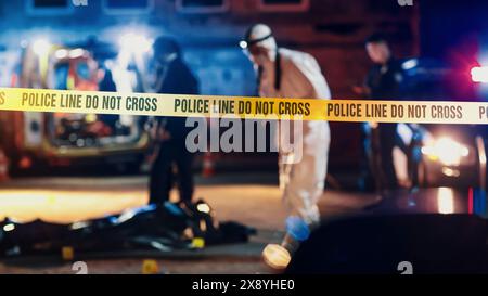 Nahaufnahme fokussiert auf gelbes Band mit Text Polizeilinie nicht kreuzen. Sperrbereich eines Tatorts. Bokeh-Hintergrund mit flackernden Sirenen. Das Forensik-Team arbeitet an einem Fall Stockfoto