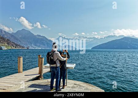 Schweiz, Kanton Luzern, Weggis, Vierwaldstättersee, Paar fotografiert den Vierwaldstättersee, im Hintergrund die Schweizer Alpen Stockfoto