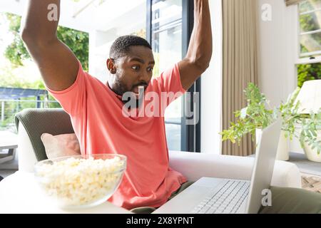 Afroamerikaner feiert vor dem Laptop zu Hause Stockfoto