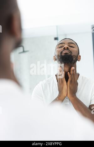 Afroamerikaner zu Hause im Badezimmer, der Rasiercreme aufträgt Stockfoto