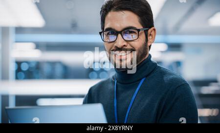 Nahaufnahme Porträt eines talentierten lateinischen Mannes, der in die Kamera schaut und charmant lächelt. Hispanischer Geschäftsmann bei der Arbeit, IT-Manager, Software-Entwickler-Profi. Stockfoto