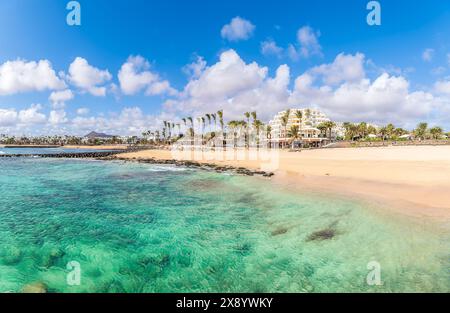 Playa de las Cucharas, Costa Teguise, Lanzarote: Ein perfekter Familienstrand mit goldenem Sand, türkisfarbenem Wasser und einer Vielzahl von Wassersportarten. Stockfoto