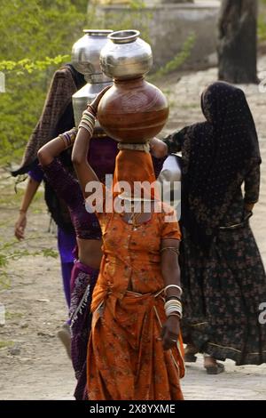 Ajmer, Indien. Mai 2024. Indische Frauen sammeln am 25. Mai 2024 Trinkwasser aus einer Wasserpumpe am Straßenrand am Hot Summer Day am Stadtrand von Ajmer im indischen Bundesstaat Rajasthan, Indien. Zwei Personen wurden als Opfer der intensiven Hitzewelle in Rajasthan gemeldet, da der Staat am Sonntag weiterhin eine heiße Hitze erlebte, wobei Phalodi wieder fast 50 Grad Celsius erreichte. Hitzewellen-Bedingungen herrschten im ganzen Bundesstaat, da die Tagestemperaturen im ganzen Bundesstaat über 43 Grad Celsius blieben, teilte das Wetteramt mit. Foto von ABACAPRESS. COM Credit: Abaca Press/Alamy Live News Stockfoto