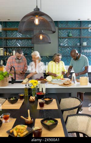 Verschiedene Seniorenfreunde kochen zu Hause zusammen Stockfoto